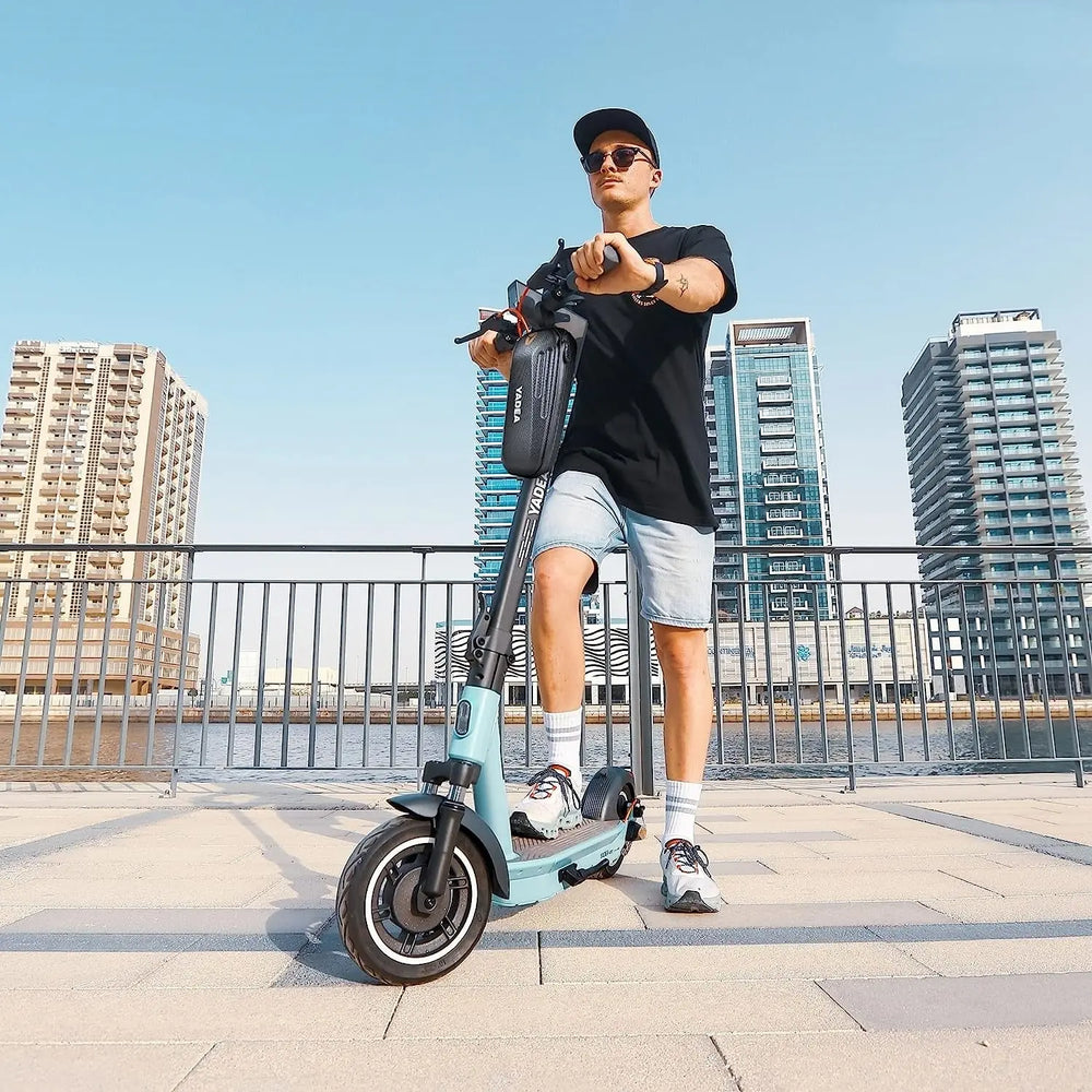 A man wearing sunglasses riding an e-scooter