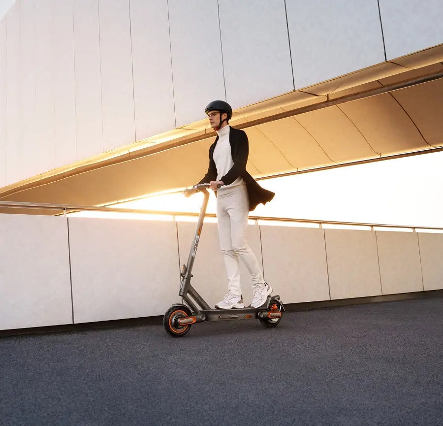 Model riding an ElitePrime electric scooter on the road